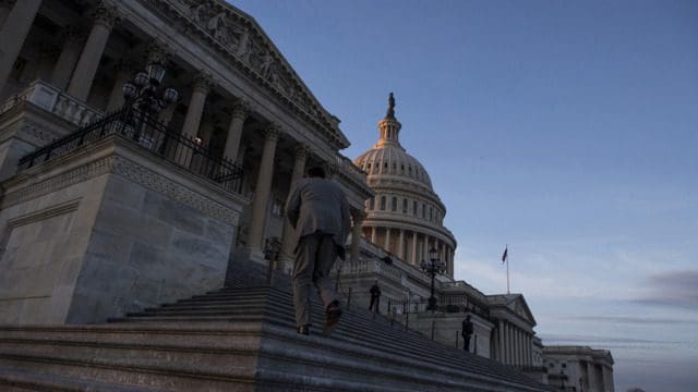 A man runs up the steps of the US Congress.
