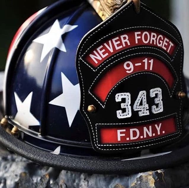 A firefighter helmet reads, "Never forget 9/11. 343 FDNY."